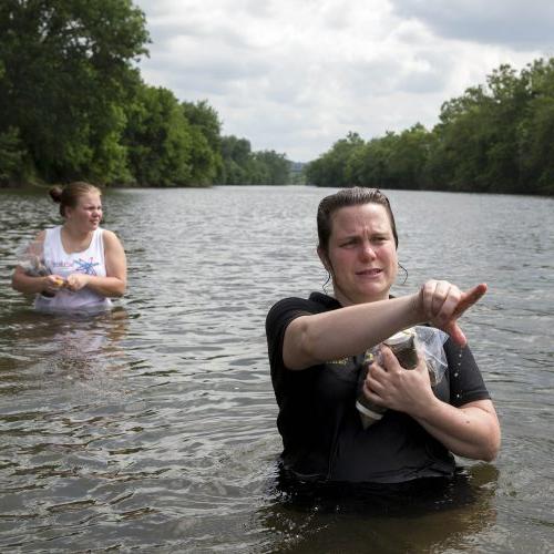 Environmental science professor Sarah Sojka collects with water samples in the James River with students.